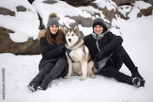 Beautiful family, a man and a girl in winter forest with dog. Pl