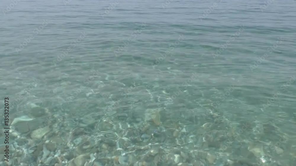 Gorgeous clean sea water splashing on the shore of pebbles Gorgeous clean sea water splashing on the shore of pebbles