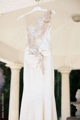 White wedding dress hanging on the street. The fees of the bride
