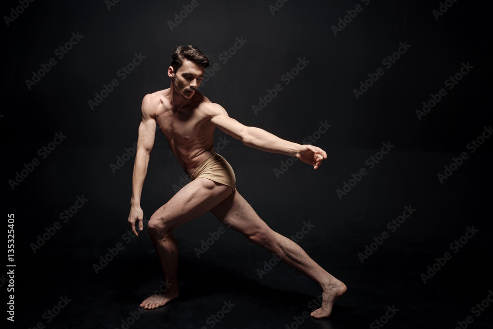 Energetic athlete performing in the black colored room