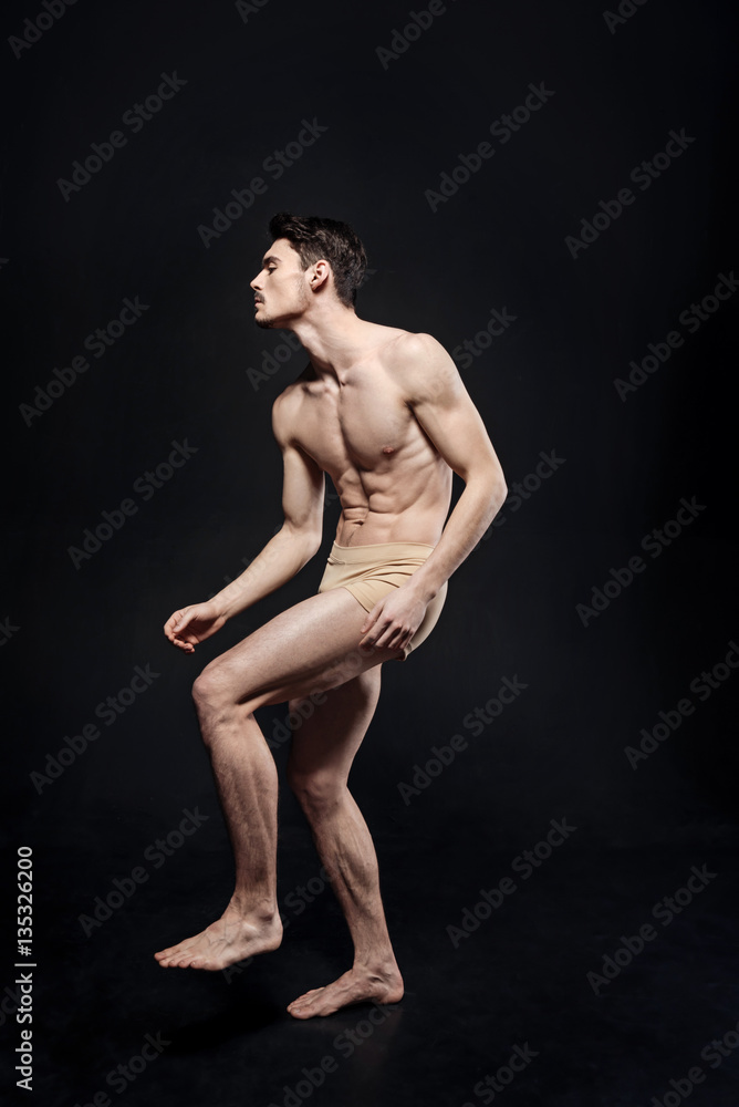 Naklejka premium Concentrated young ballet dancer performing in the studio