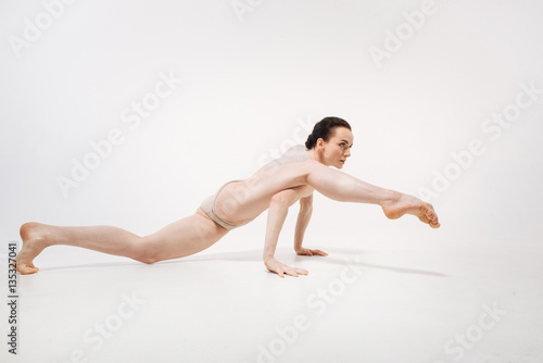 Flexible young ballet dancer stretching in the studio