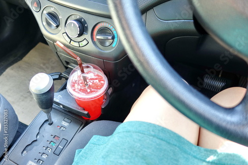Icy juice drink in cup holder in car, hot da