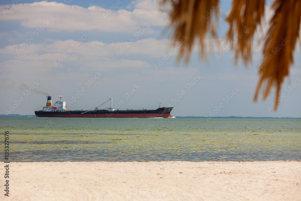 Oil Tanker Sailing Past Tropical Beach and Palm Tree