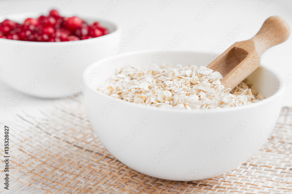 Rolled oats, porridge and cranberries for a healthy breakfast in a rustic style Rolled oats, porridge and cranberries for a healthy breakfast in a rustic style