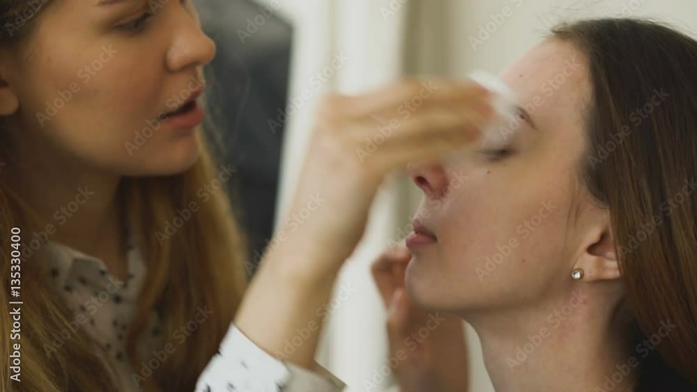 Young make-up artist makes a girl beautiful makeup for face before closeup an important event Young make-up artist makes a girl beautiful makeup for face before closeup an important event