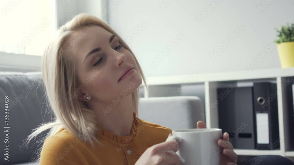 Thoughtful young woman at home with cup of coffee Thoughtful young woman at home with cup of coffee