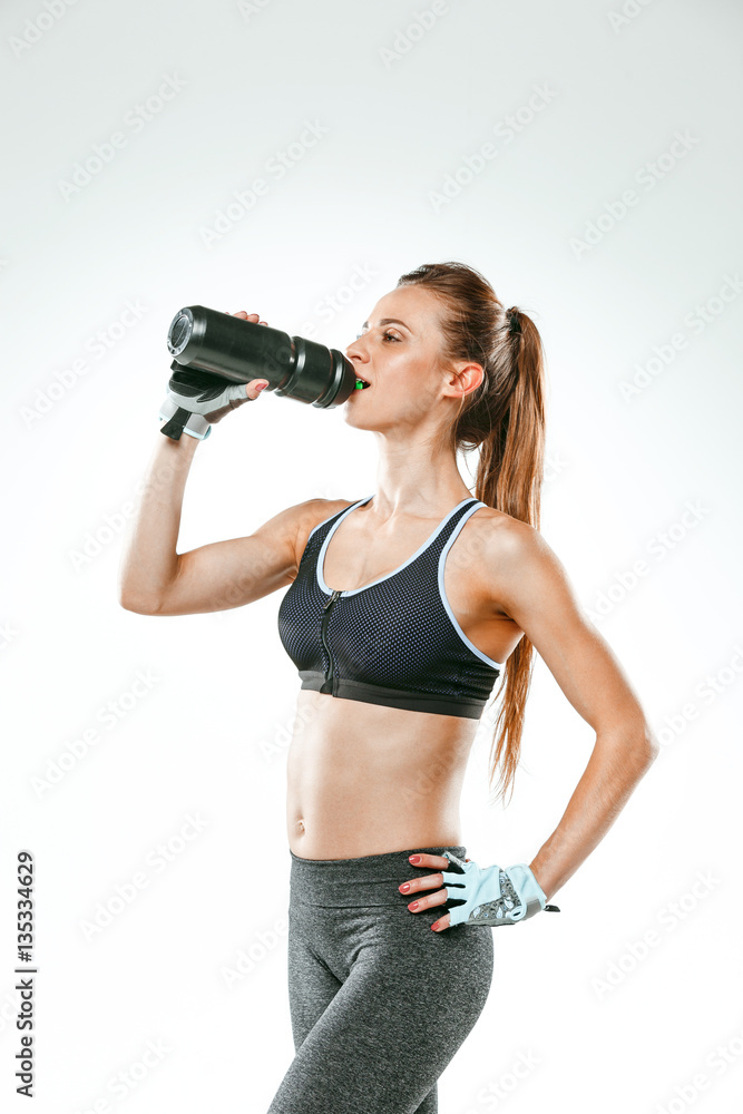 Muscular young woman athlete with a water on black Muscular young woman athlete with a water on black