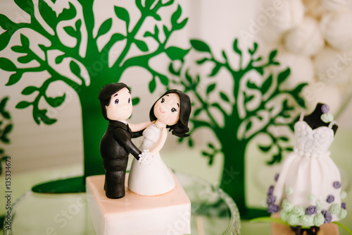 Bride and groom on a wedding cake. Confectionery sculpture. photo