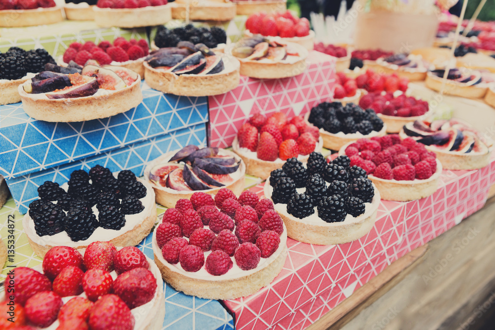 Fruit and berry tarts dessert tray assorted outdoors Fruit and berry tarts dessert tray assorted outdoors