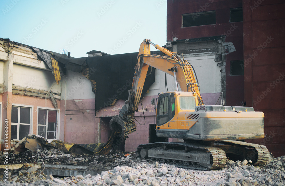 Hydraulic demolition crane dismantling school building. Hydraulic demolition crane dismantling school building.
