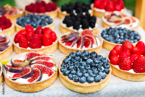 Fruit and berry tarts dessert tray assorted outdoors