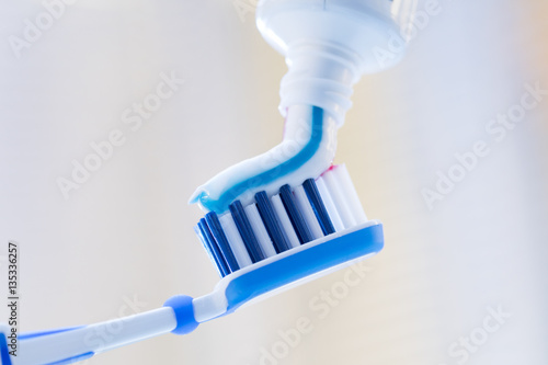 Zbliżenie szczoteczki do zębów i pasty do zębów na niewyraźne tło