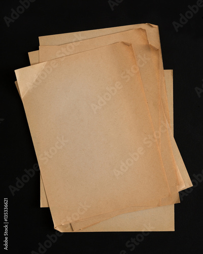 old craft paper sheets pile isolated on black background