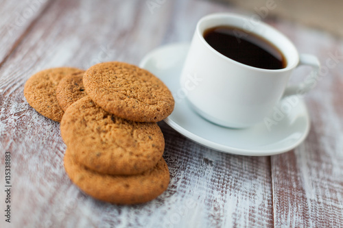 Cup of coffee, cookies, walnut and chocolate on the white wooden