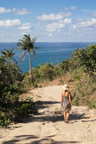 Woman walking on tropical island near the sea and palms