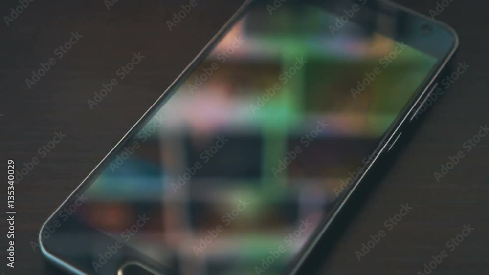 Smartphone with scrolling gallery page monitor reflections on the background. Down sliding. Smartphone with scrolling gallery page monitor reflections on the background. Down sliding.