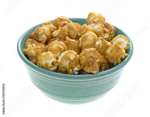 Toffee caramel popcorn in a green bowl isolated on a white background.