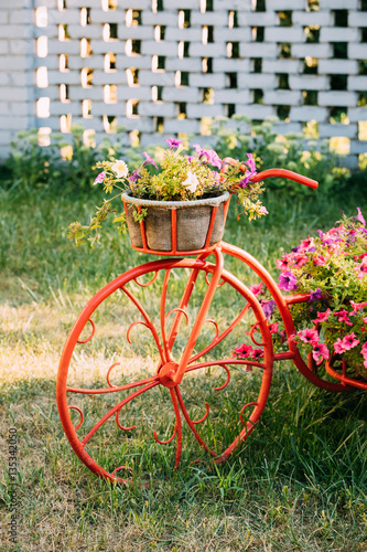 Decorative Vintage Model Old Bicycle Equipped Basket Flowers Garden. Toned Photo.