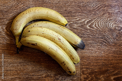 Fotografija Four ripe bananas on a wooden table
