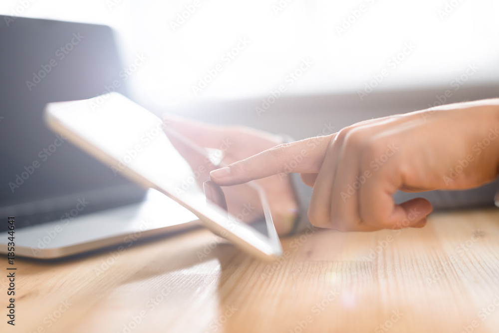 Hands using tablet screen at workspace