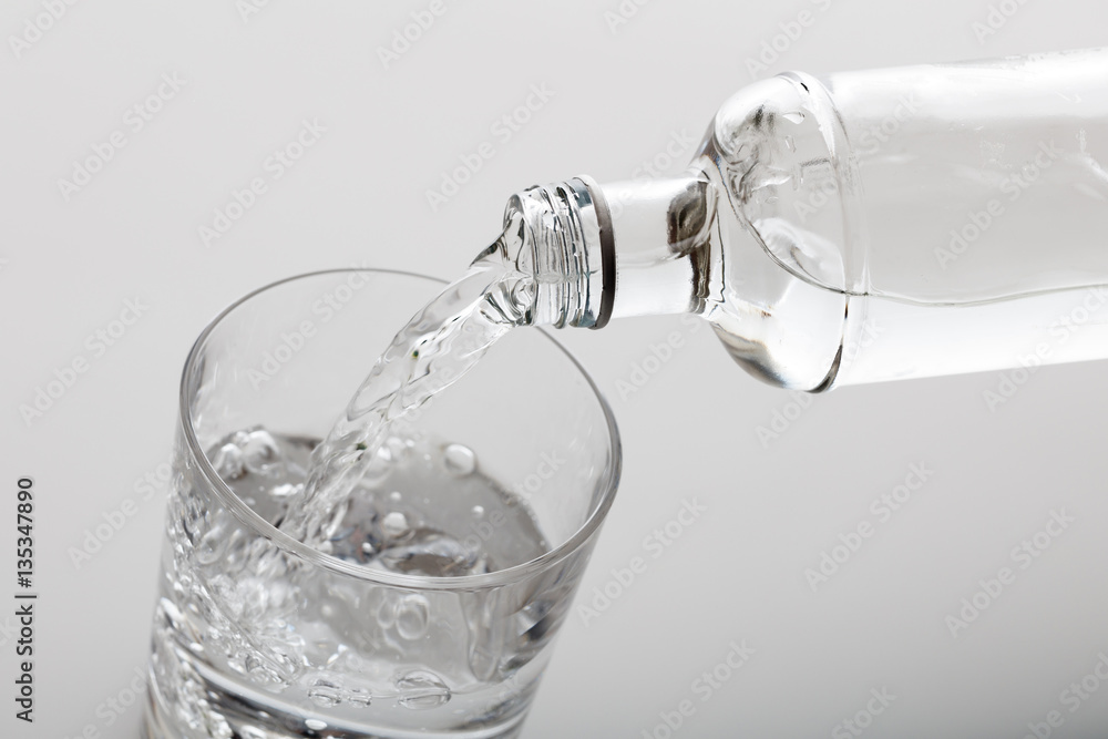 Pouring water in a glass on white background Pouring water in a glass on white background