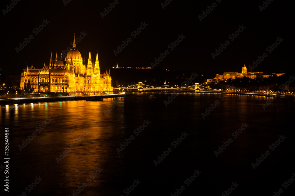 Hungarian Parliament Building located at the bank of the Dunabe river with famous Chain Bridge connecting Buda and Pest in Budapest, Hungary