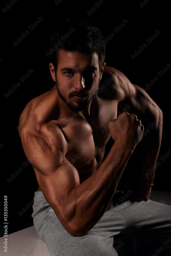 Handsome male model posing and showing his arm muscles Handsome male model posing and showing his arm muscles
