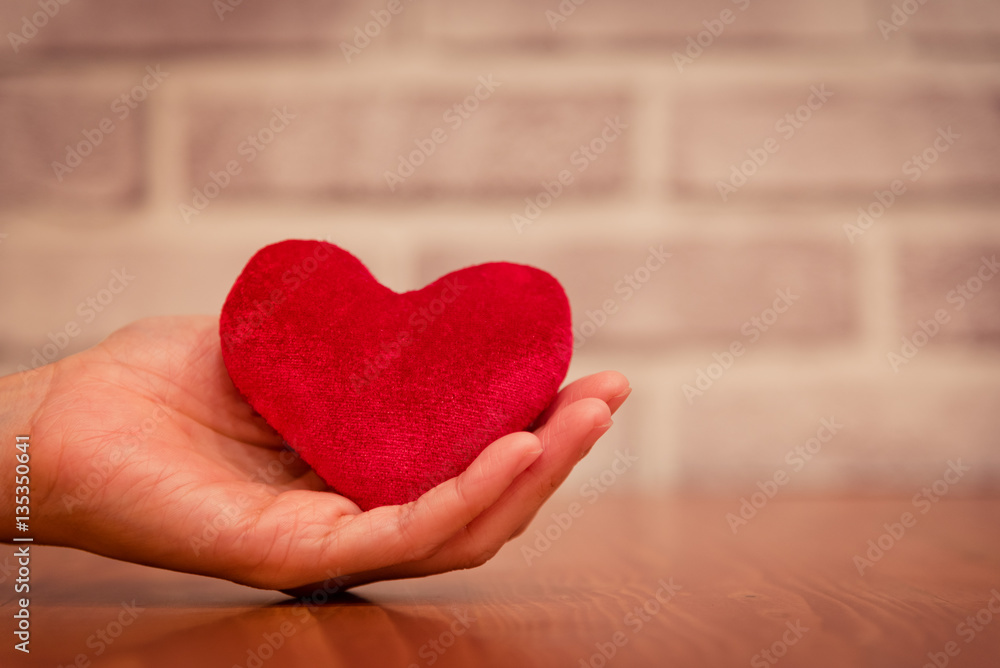 Φωτογραφία Close up of woman hands holding heart on wooden table in love an