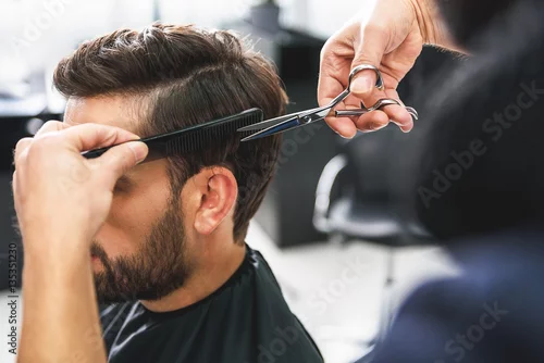 Obraz Barber using scissors and comb