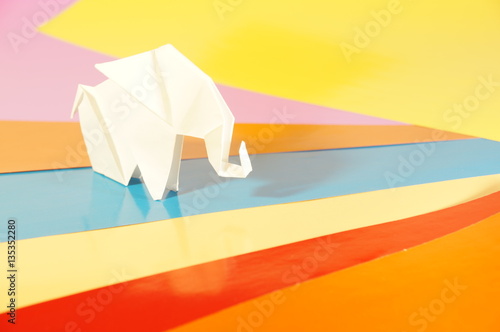   Paper origami elephant isolated on a colorful background