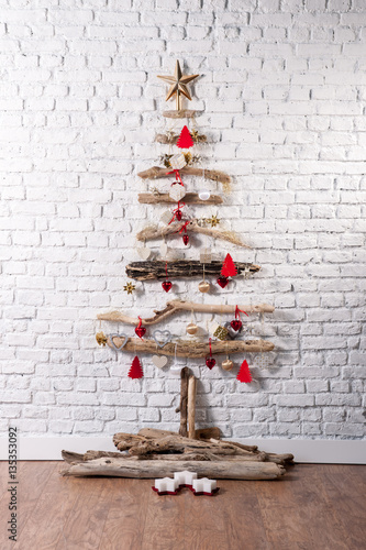 christmas tree with colourful ornaments over white brick wallpaper photo