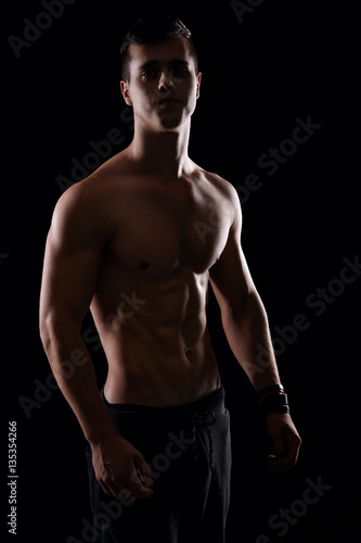 Handsome male model posing and showing his muscular body