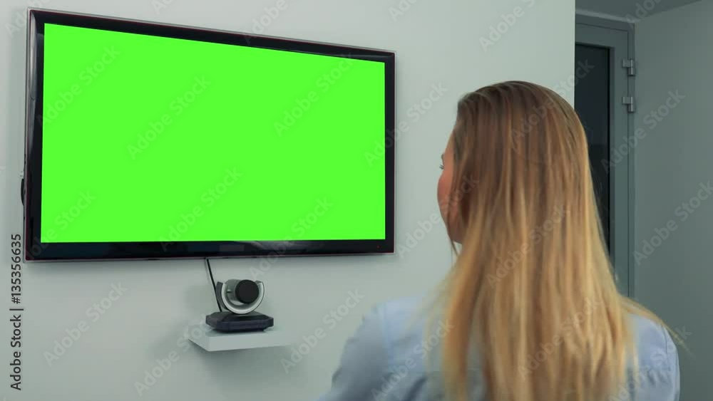 A woman dances in front of a green television screen A woman dances in front of a green television screen