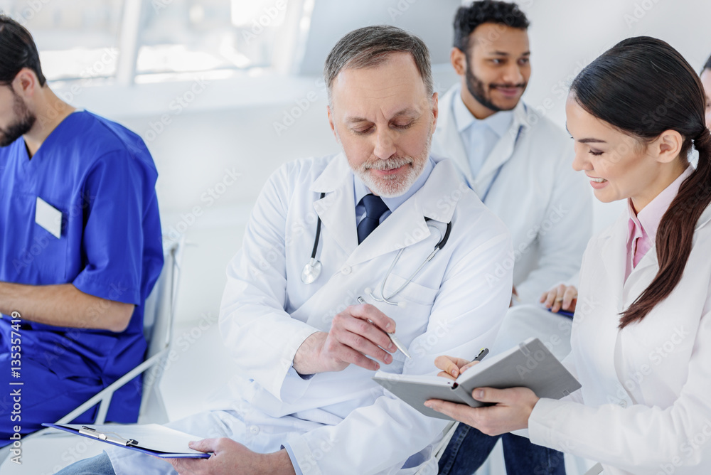 Experienced doctor undersigning papers at hospital Experienced doctor undersigning papers at hospital