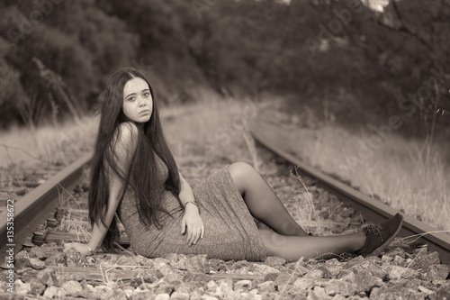 Young woman sitting on the train track photo
