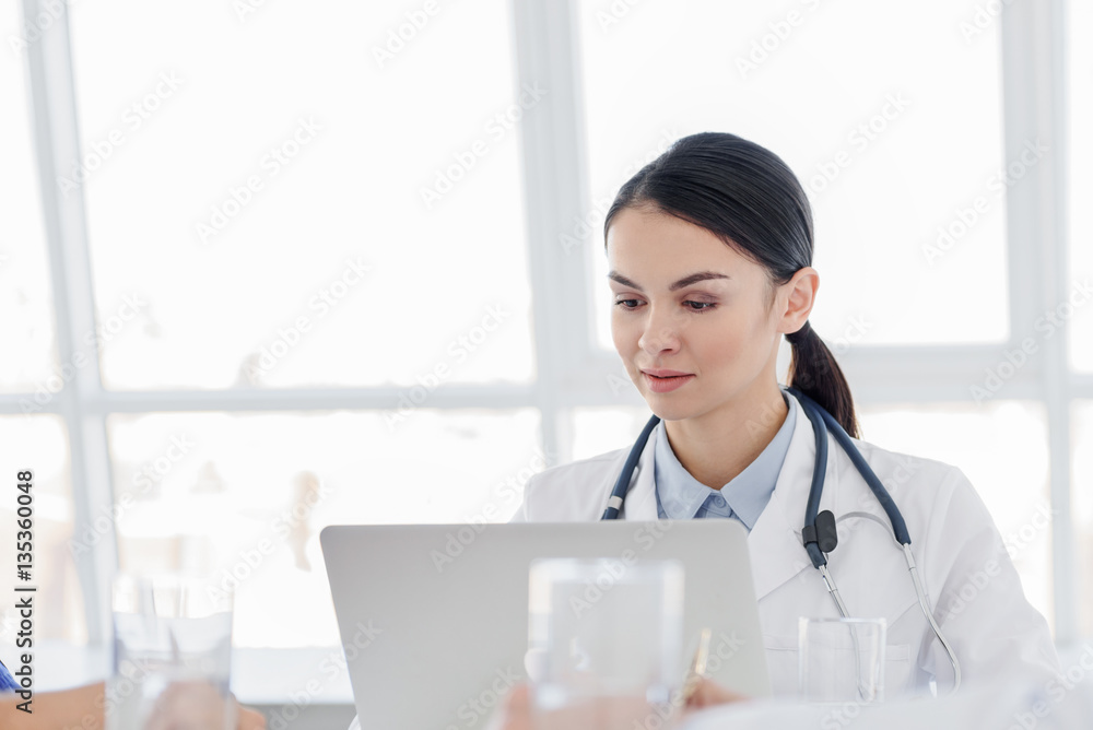 Skillful young physician working on computer Skillful young physician working on computer