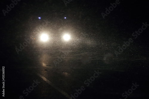 Машина едет ночью видно фары идёт снег