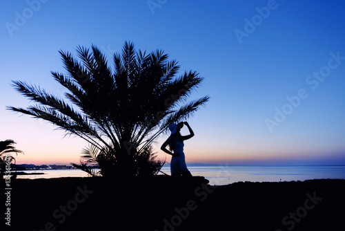 Girl silhouette at sunset. Beautiful sea view at sunset. Tropic Island. Cypru...