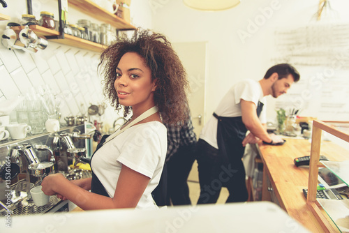 Cheerful barista starting out preparing tasty coffee
