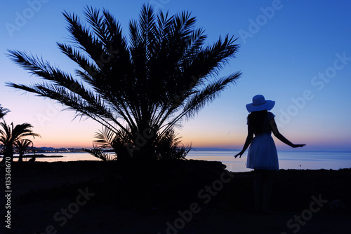 Girl silhouette at sunset. Beautiful sea view at sunset. Tropic Island. Cypru...