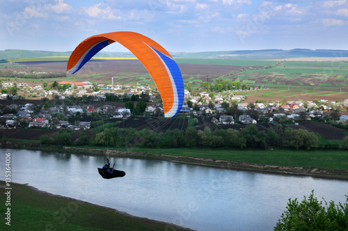 Paragliding over river valley in the summer sunny day. Dniester river, Ukraine