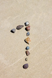 Number one made of stones on the sand