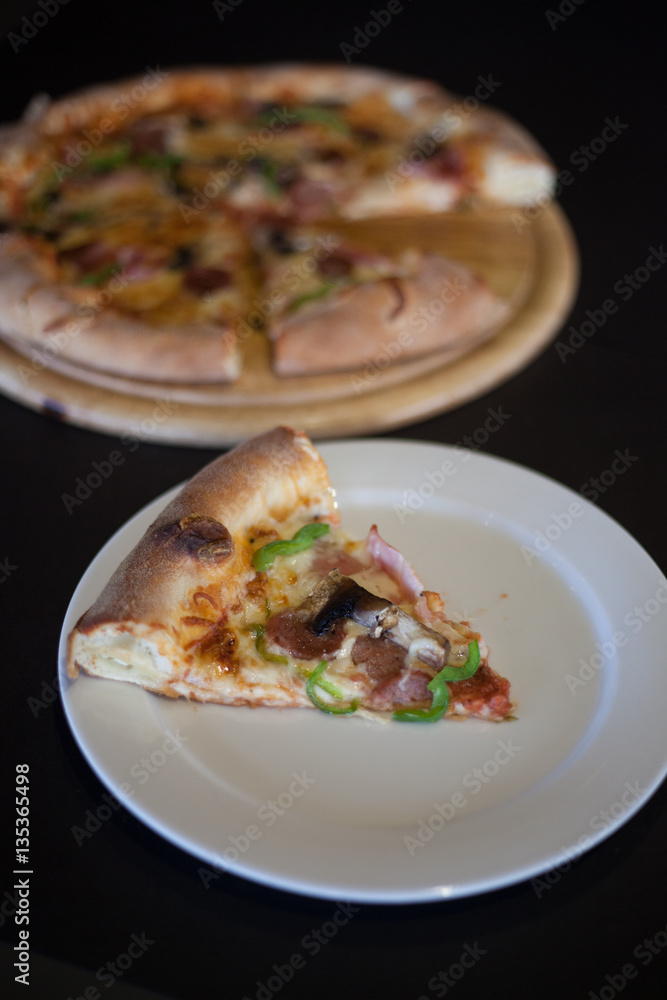 Slice of pizza on white dish Slice of pizza on white dish