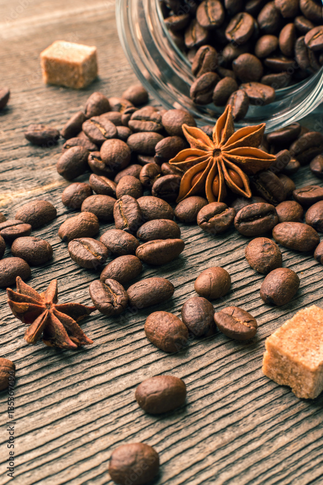 Coffee beans into glass jar table with sugar and anise Coffee beans into glass jar table with sugar and anise