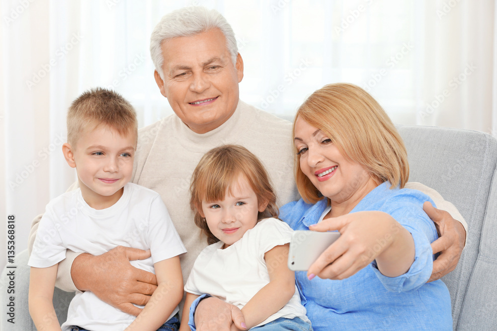 Happy family taking selfie on couch