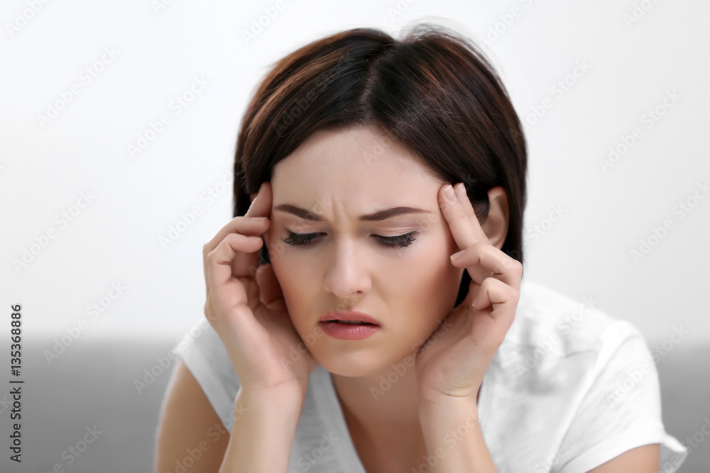 Beautiful young woman suffering from headache at home, close up