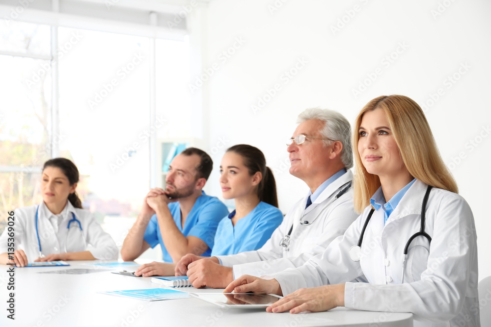 Team of doctors sitting at table in clinic