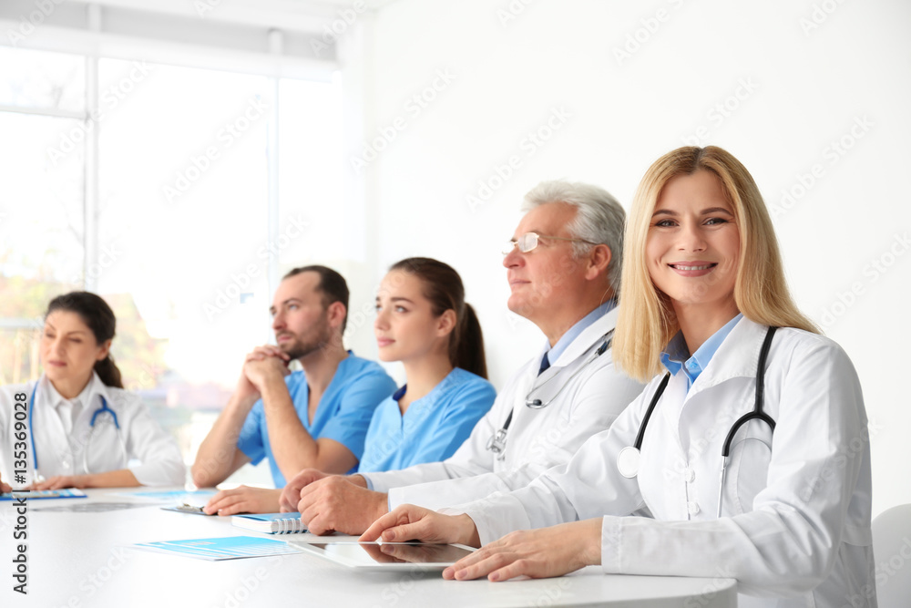 Team of doctors sitting at table in clinic Team of doctors sitting at table in clinic