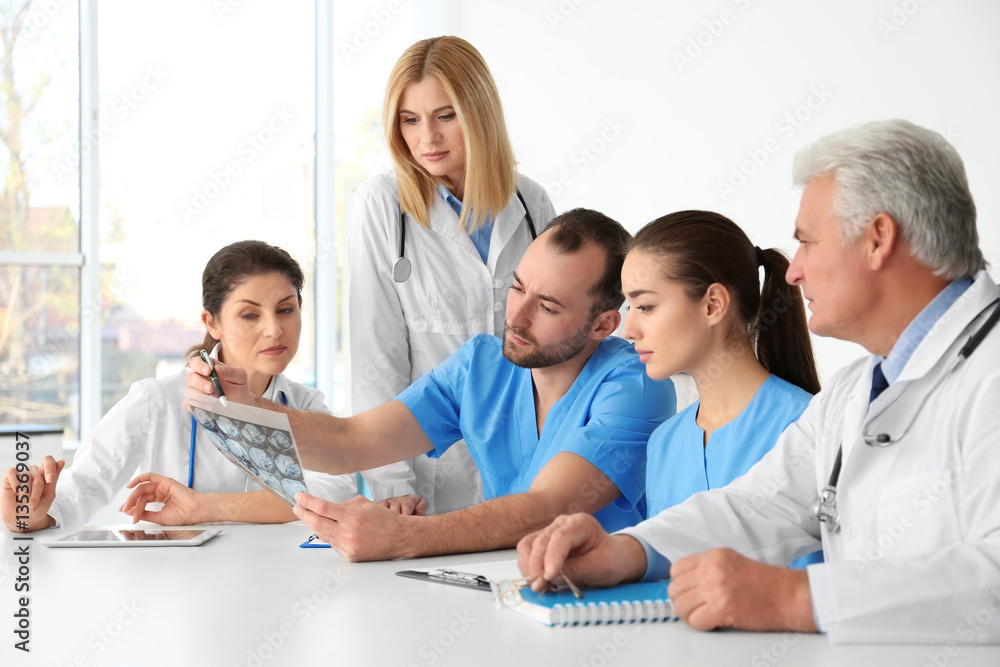 Team of doctors exploring roentgenogram at meeting Team of doctors exploring roentgenogram at meeting